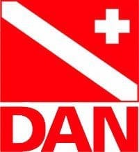 Diver-Alert-Network_resized Red DAN logo showing a white diagonal diver-down stripe, a white medical cross in the top-right, and "DAN" in bold letters below.
