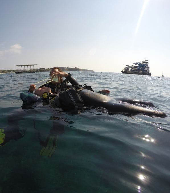 Rescue – 2 Scuba instructor assisting a floating diver with regulator during a surface rescue near Nusa Penida